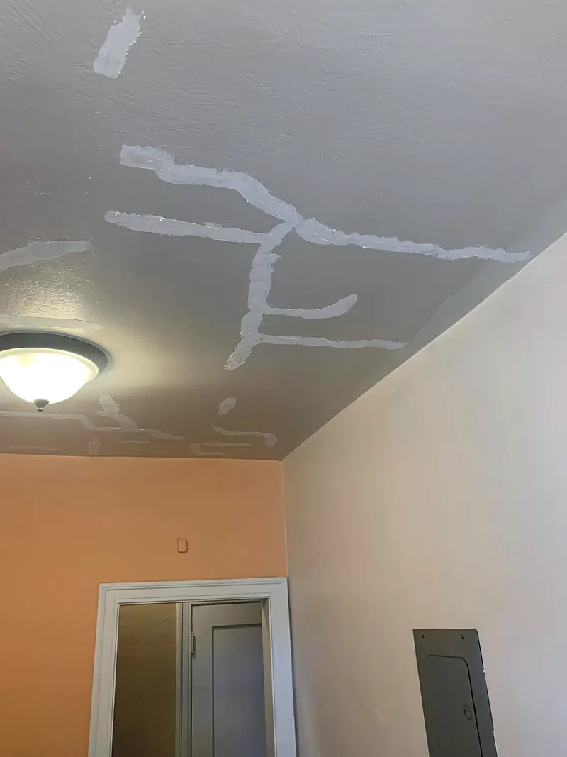 Ceiling cracks taped and covered with fresh joint compound before sanding and paint
