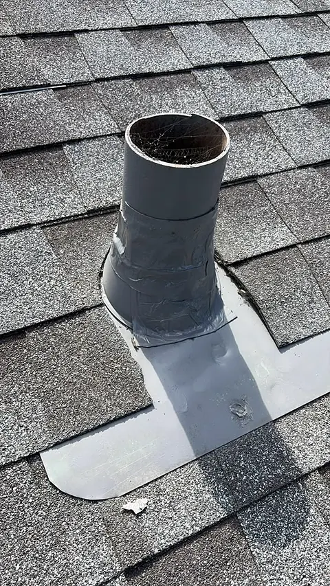 Vent pipe on an asphalt shingle roof with new flashing sealed to the shingles